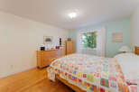 Bright and airy bedroom featuring a comfortable bed adorned with a colorful patchwork quilt.