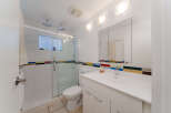 Experience modern comfort in this beautifully appointed bathroom, featuring a spacious glass-enclosed shower with dual showerheads and a sleek vanity with a large mirror.