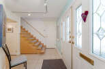 Step into a welcoming entryway featuring a stylish staircase with wooden treads and carpeted steps, perfect for a cozy home.