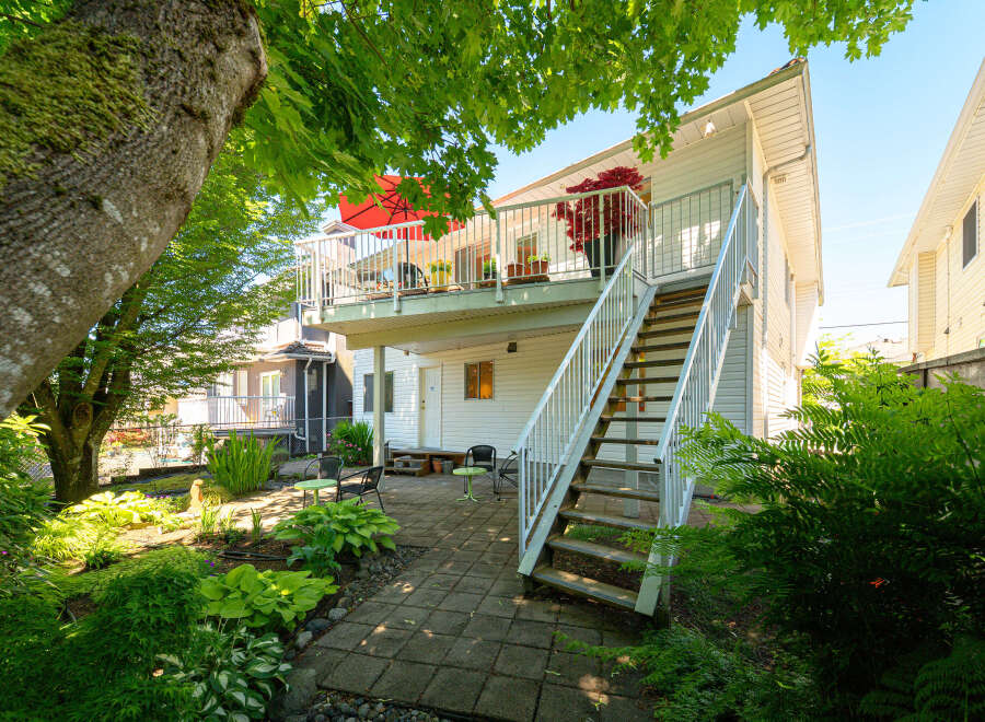 Enjoy outdoor living with this charming backyard featuring a spacious deck and a paved patio area perfect for entertaining.