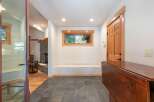 Step into this inviting entryway featuring a cozy stone fireplace and warm wood accents throughout.