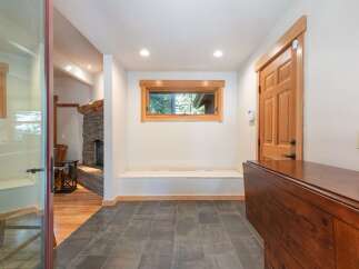 Step into this inviting entryway featuring a cozy stone fireplace and warm wood accents throughout.