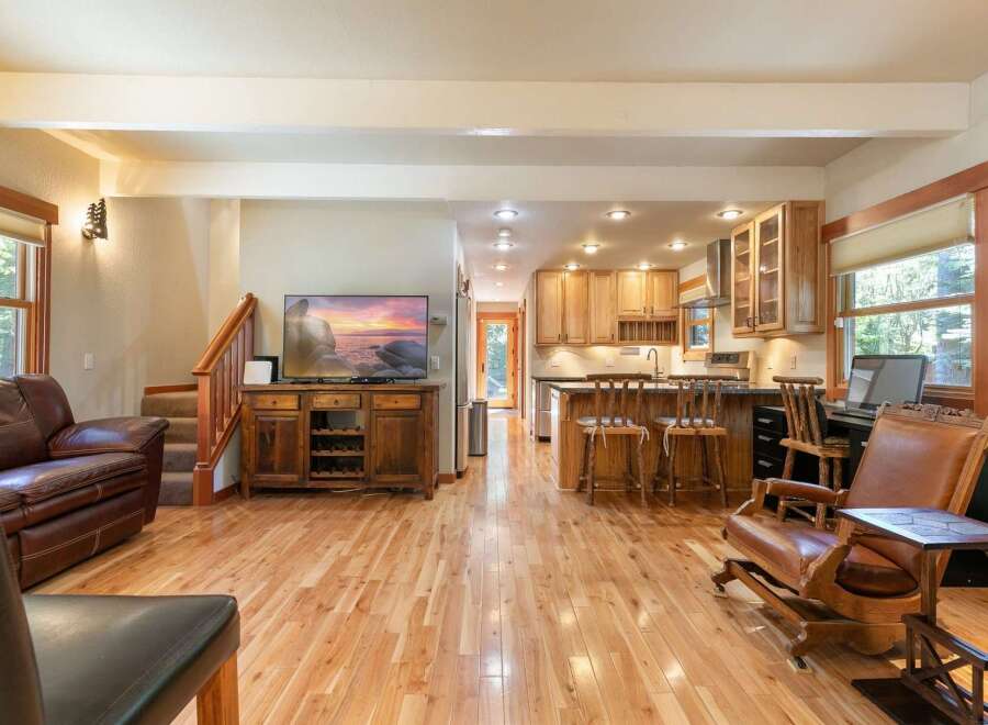 Experience the perfect blend of comfort and style in this open-concept living space, featuring a spacious living area with a plush leather sofa and a modern entertainment center.