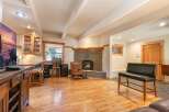Cozy living room featuring a rustic stone fireplace with a natural wood mantel, perfect for gathering on cool evenings.