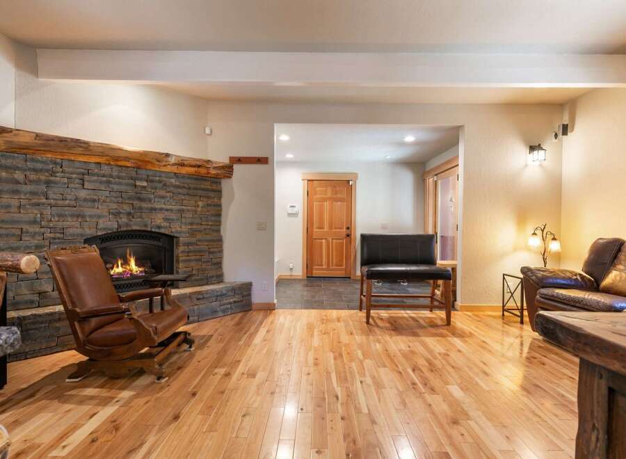 Experience rustic charm in this inviting living space, featuring a magnificent stone fireplace with a natural wood mantel.