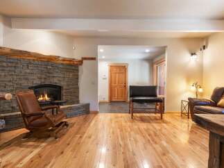 Experience rustic charm in this inviting living space, featuring a magnificent stone fireplace with a natural wood mantel.