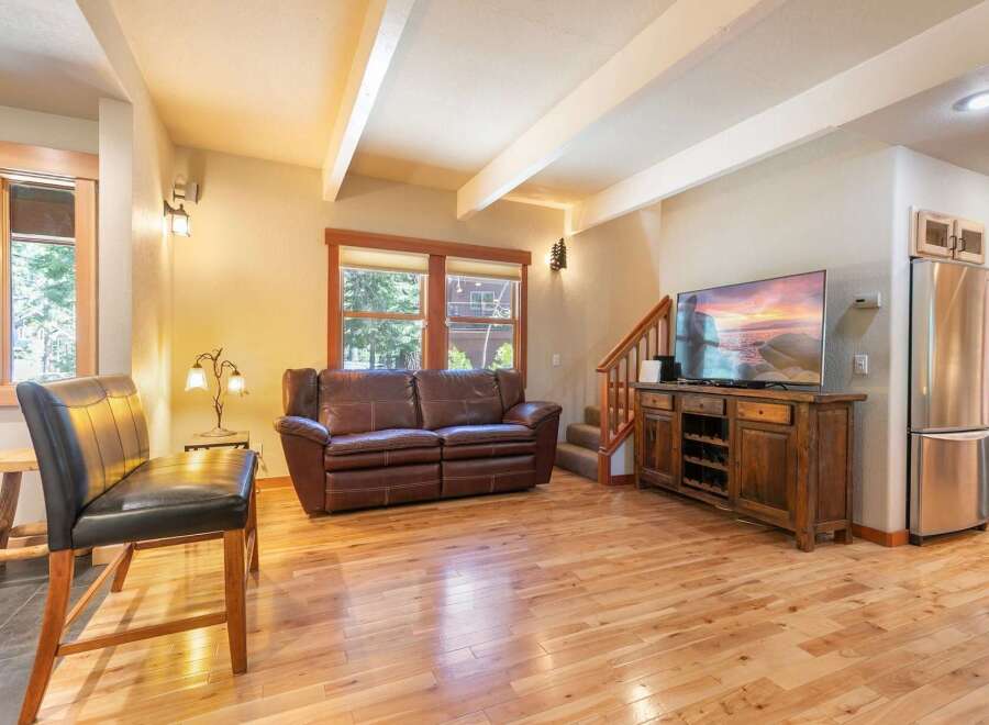 Experience rustic charm in this inviting living space, featuring a plush leather sofa perfect for relaxation and a large flat-screen TV for entertainment.
