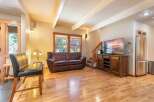Experience rustic charm in this inviting living space, featuring a plush leather sofa perfect for relaxation and a large flat-screen TV for entertainment.