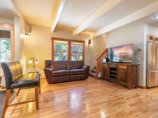 Experience rustic charm in this inviting living space, featuring a plush leather sofa perfect for relaxation and a large flat-screen TV for entertainment.