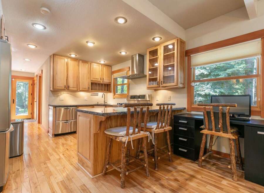 This charming kitchen features light wood cabinetry and a spacious island with granite countertops, perfect for meal preparation and casual dining.
