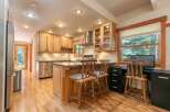 This charming kitchen features light wood cabinetry and a spacious island with granite countertops, perfect for meal preparation and casual dining.
