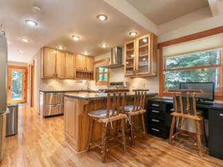 This charming kitchen features light wood cabinetry and a spacious island with granite countertops, perfect for meal preparation and casual dining.