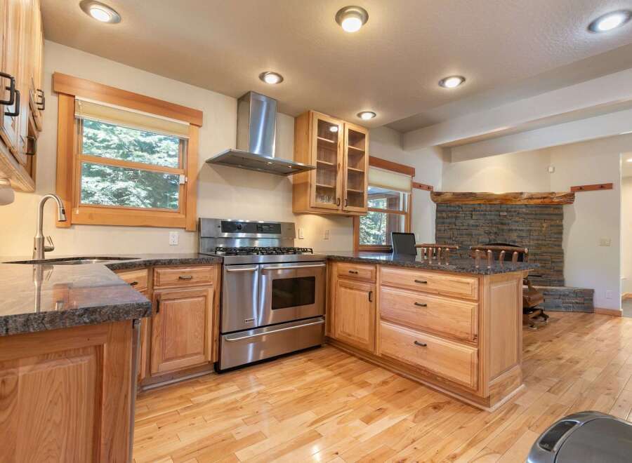 Discover this charming kitchen featuring a professional-grade stainless steel gas range and a sleek range hood, perfect for culinary enthusiasts.