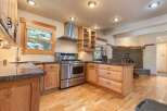 Discover this charming kitchen featuring a professional-grade stainless steel gas range and a sleek range hood, perfect for culinary enthusiasts.