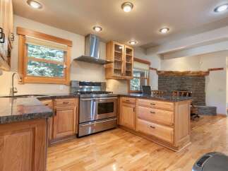 Discover this charming kitchen featuring a professional-grade stainless steel gas range and a sleek range hood, perfect for culinary enthusiasts.