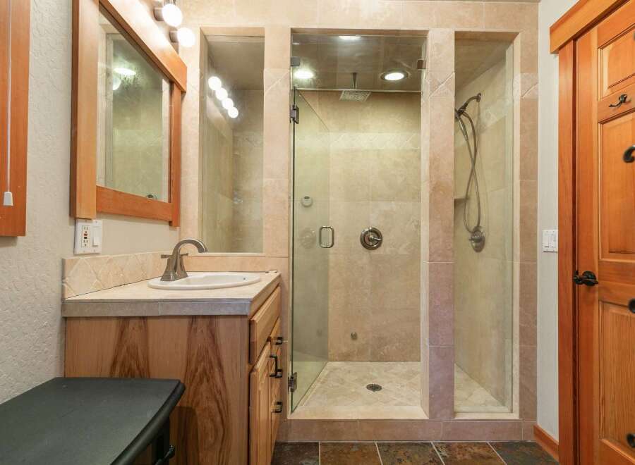 Experience luxury in this spacious bathroom featuring a walk-in shower with dual shower heads and elegant tilework.