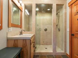 Experience luxury in this spacious bathroom featuring a walk-in shower with dual shower heads and elegant tilework.