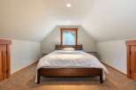 Discover this charming bedroom featuring a cozy queen-size bed with a plush white duvet, perfect for restful nights.