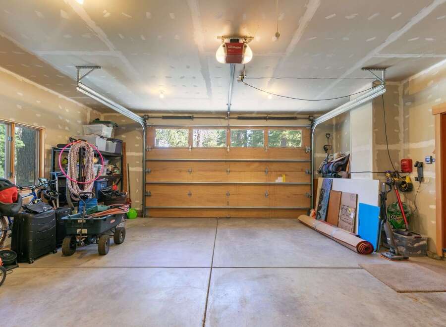 This spacious garage offers ample storage solutions with shelving units and plenty of floor space for vehicles and equipment.