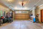 This spacious garage offers ample storage solutions with shelving units and plenty of floor space for vehicles and equipment.