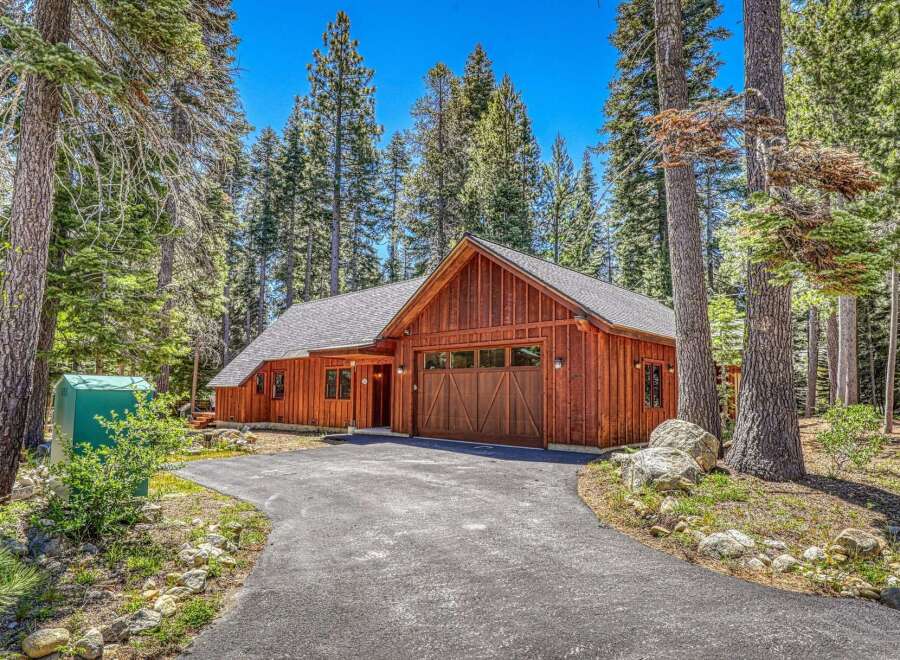 Nestled amongst tall pine trees, this charming wooden home offers a serene retreat.