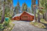 Nestled amongst tall pine trees, this charming wooden home offers a serene retreat.