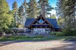 Experience lakeside dining at this stunning property, featuring a rustic A-frame lodge with expansive windows overlooking the water.