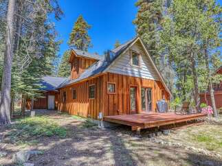 Experience mountain living in this charming wooden A-frame cabin nestled amongst tall pine trees.
