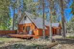 Nestled amongst tall pine trees, this charming cabin offers a serene mountain retreat.