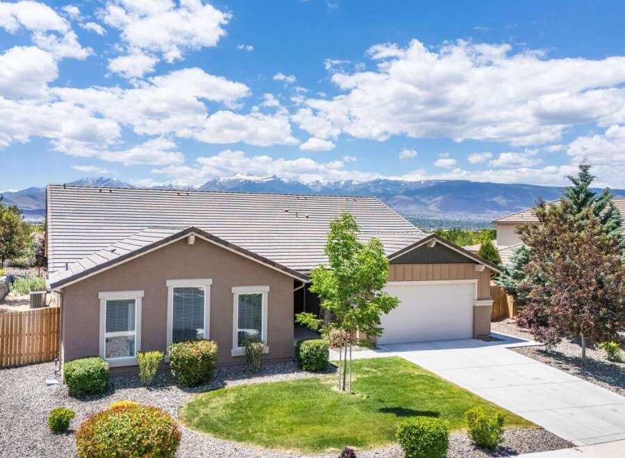 Discover this stunning home with a beautifully landscaped front yard and a spacious driveway leading to an attached garage.