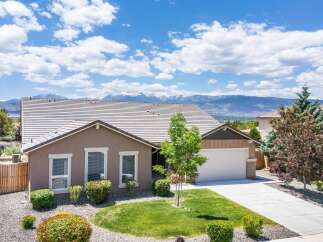 Discover this stunning home with a beautifully landscaped front yard and a spacious driveway leading to an attached garage.