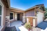 Welcome to this charming home featuring a welcoming covered porch with stone accents and a dark wood front door.