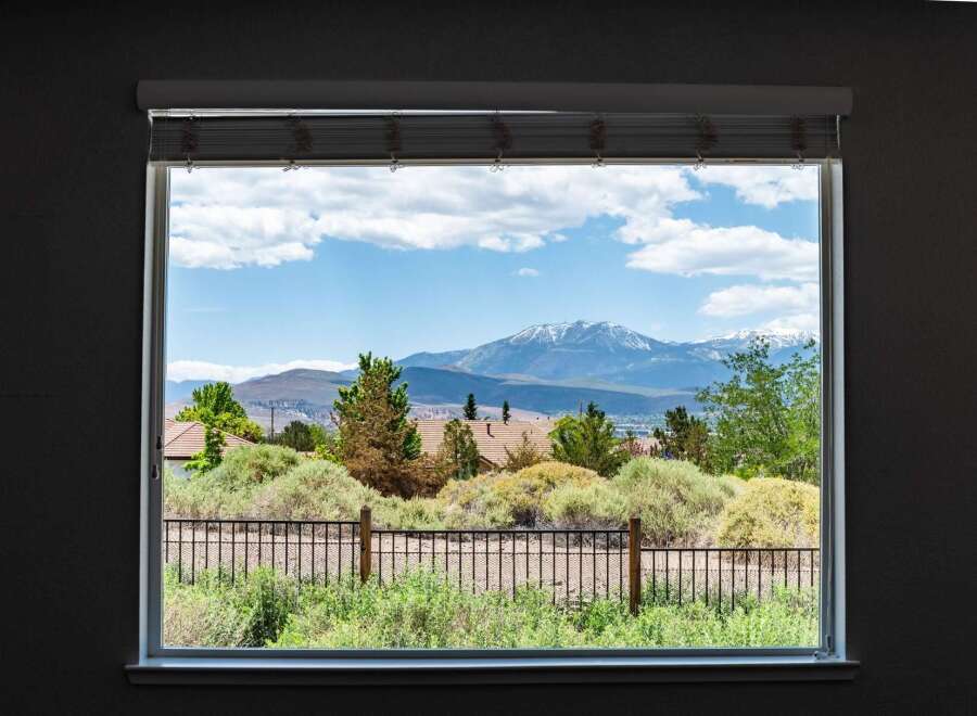 Enjoy breathtaking mountain views from this stunning property, framed perfectly by a large window.