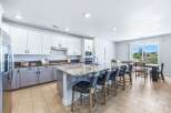 Experience modern living in this spacious kitchen featuring sleek white cabinetry and a large granite island perfect for entertaining.