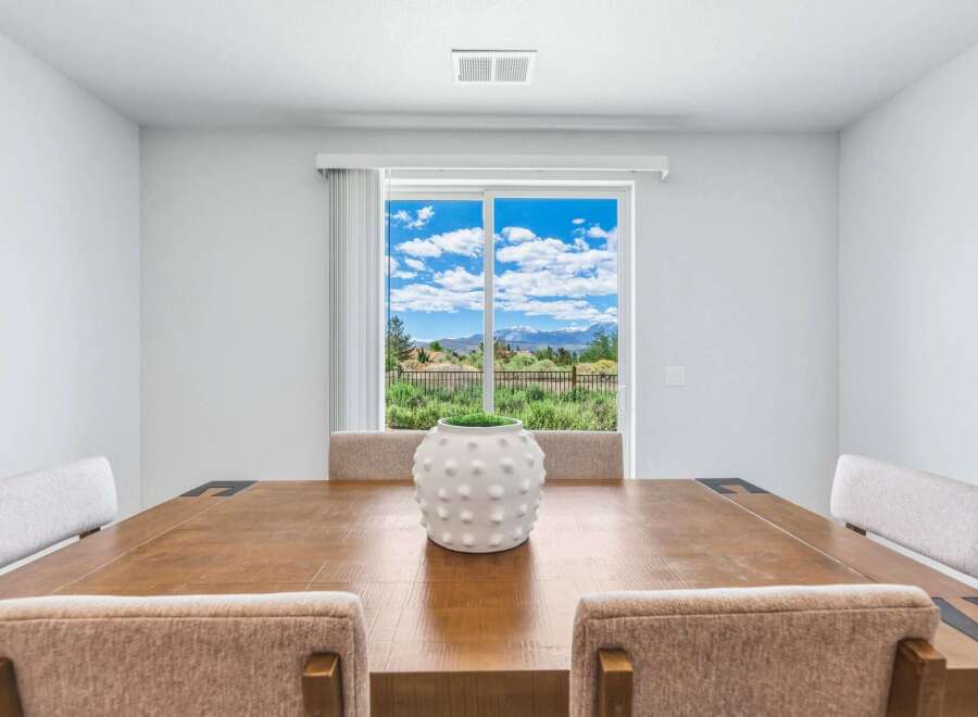 Enjoy breathtaking mountain views from this elegant dining room, featuring a large sliding glass door that floods the space with natural light.