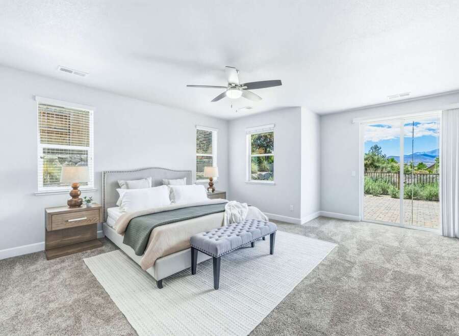 Experience luxurious living in this stunning master bedroom, featuring a plush king-sized bed with a tufted headboard and a cozy green throw.