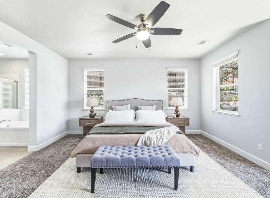 Experience ultimate comfort in this spacious master bedroom, featuring a plush king-sized bed with a stylish upholstered headboard and a luxurious tufted bench at the foot of the bed.