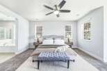 Experience ultimate comfort in this spacious master bedroom, featuring a plush king-sized bed with a stylish upholstered headboard and a luxurious tufted bench at the foot of the bed.