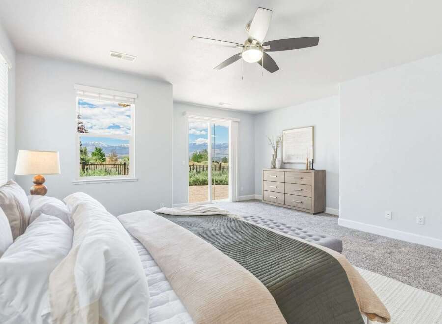 Experience breathtaking mountain views from this serene master bedroom, featuring a spacious layout and direct access to an outdoor patio.