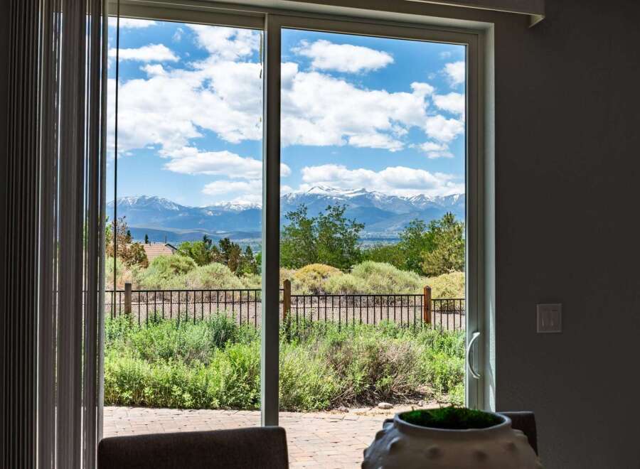 Experience breathtaking mountain views from this stunning property, framed by a large sliding glass door.