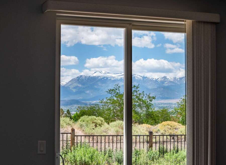 Experience breathtaking mountain views from this stunning property, framed perfectly by a large sliding glass door.