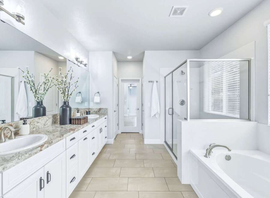 Experience luxury in this stunning master bathroom, featuring a spacious double vanity with granite countertops and ample storage.