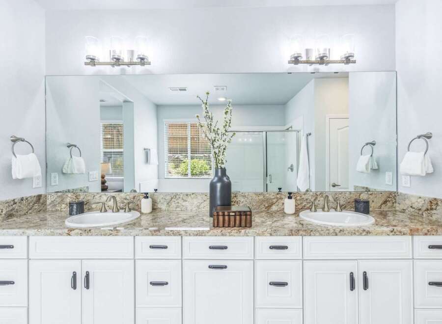 This spacious master bathroom features a double vanity with granite countertops and undermount sinks, perfect for busy mornings.
