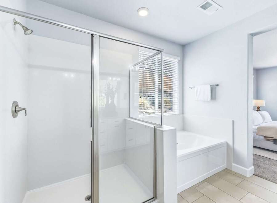 Experience luxury in this stunning master bathroom, featuring a spacious glass-enclosed shower and a deep soaking tub perfect for relaxation.