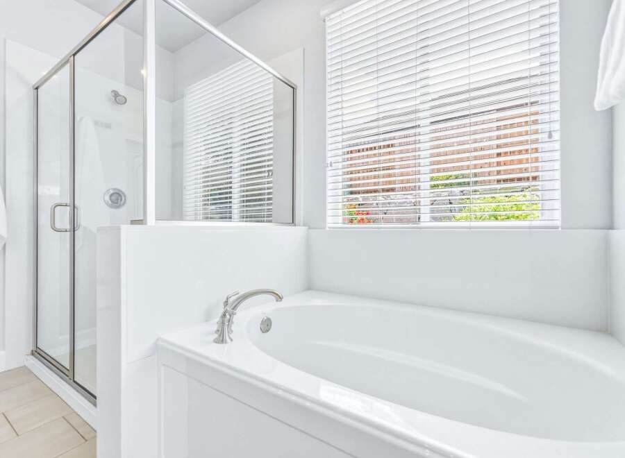 Experience modern luxury in this stunning bathroom featuring a spacious soaking tub and a separate glass-enclosed shower.