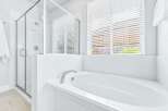 Experience modern luxury in this stunning bathroom featuring a spacious soaking tub and a separate glass-enclosed shower.
