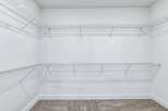 This spacious walk-in closet features ample wire shelving, perfect for organizing your wardrobe.