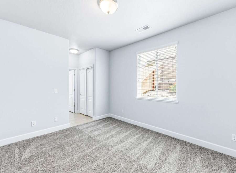 Step into this bright and airy room, featuring plush grey carpeting that adds warmth and comfort.
