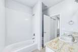 This bathroom features a pristine white bathtub and shower combo, perfect for relaxing soaks or quick rinses.