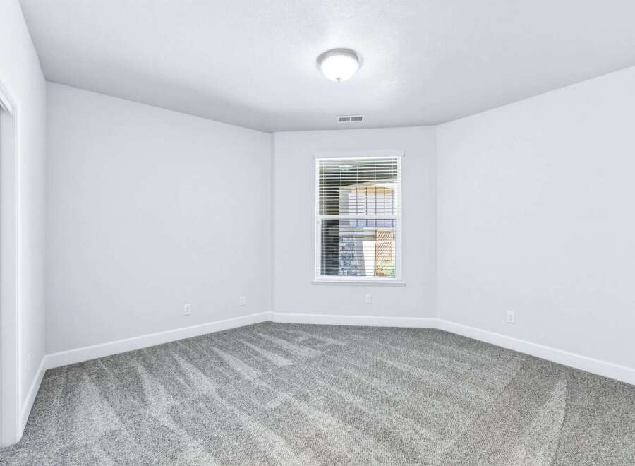 Step into this inviting bedroom, featuring plush grey carpeting that adds warmth and texture to the space.